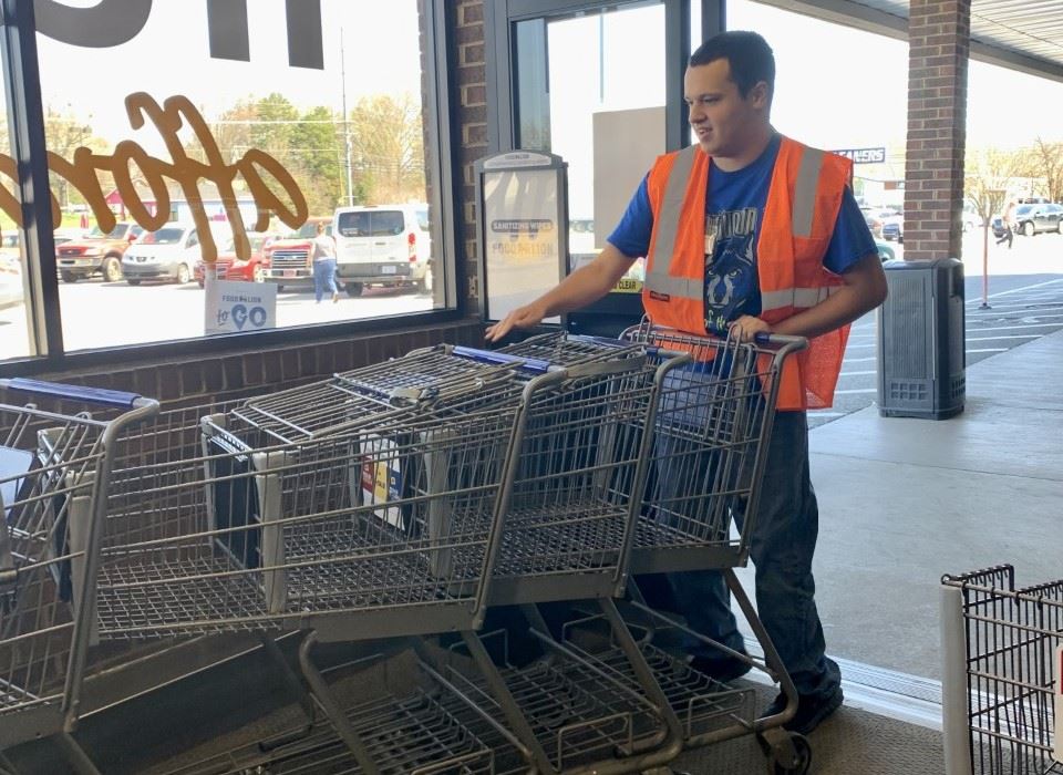 Student gather grocery carts during on the job training.